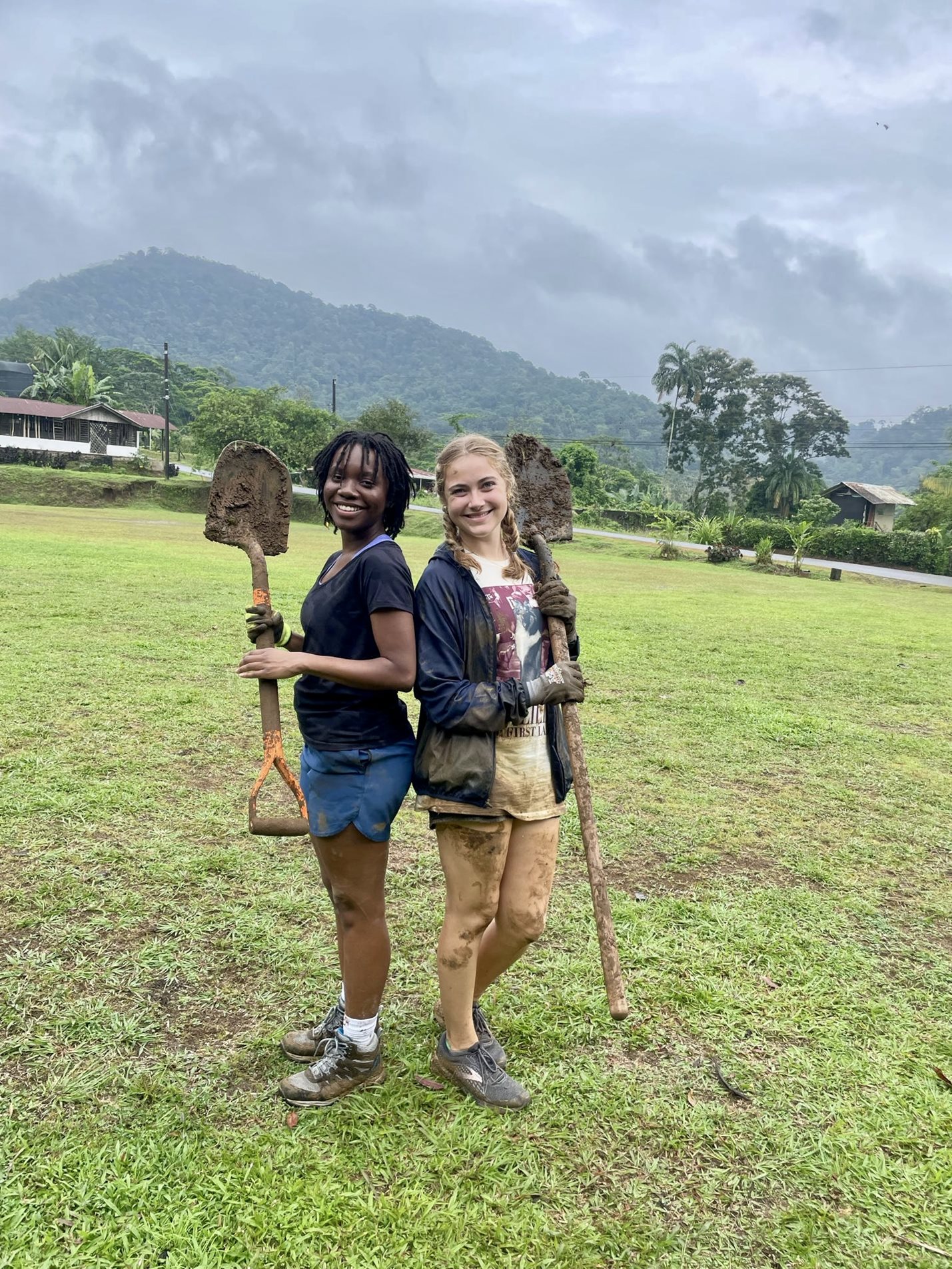 Two students holding shovels in a field at the Soltis Center in Costa Rica