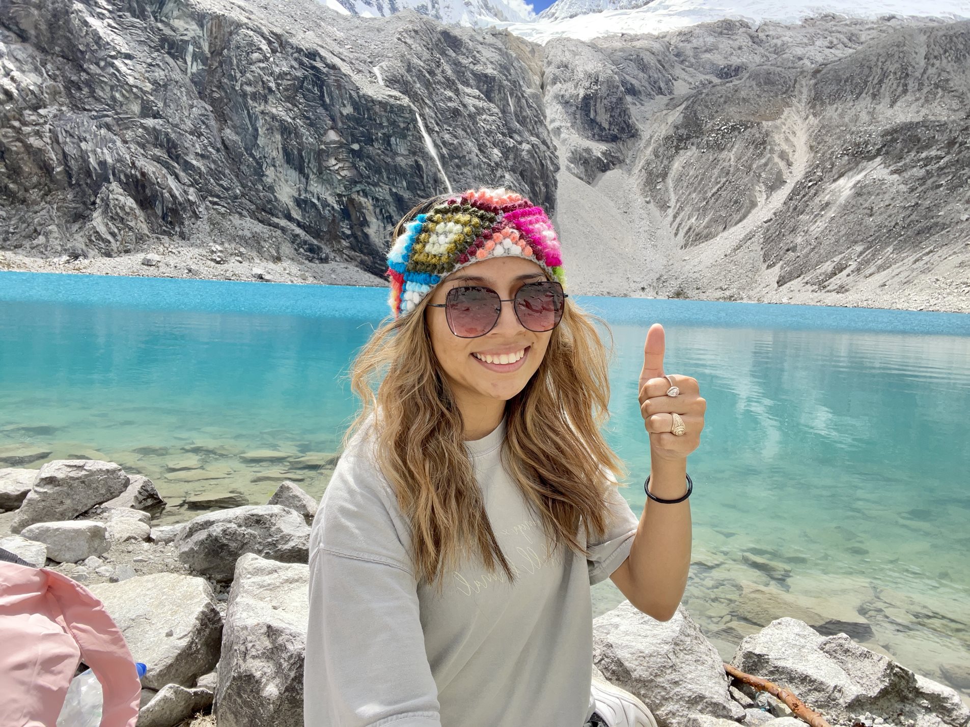 woman showing thumbs up in front of a lake in Peru